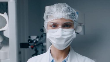 İyi donanımlı bir dişçi kliniğinde koruyucu giysiler giyen bir dişçi kadın. Modern ayar ileri teknolojiyi sergiliyor, hasta bakımı ve rahatlığının önemini vurguluyor..