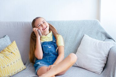 Telefon konuşması. Neşeli, sıradan bir çocuk bej koltukta oturmuş, bakıyor.