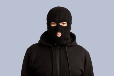 İsyanlar, Hırsızlık ve Yağmacılık Konsepti. Siyah maskeli kötü adamın portresi beyaz arka planda kameraya poz veriyor.