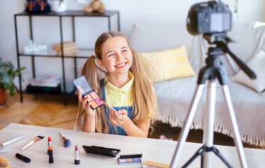 Blog Kavramı. Genç kadın vlogger kameranın yanında oturuyor ve internet kanalı için video kaydediyor.