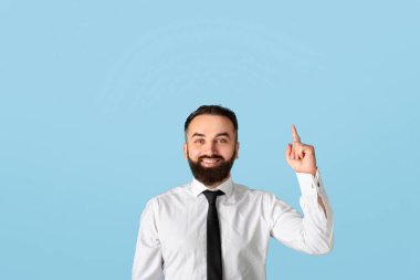 Bin yıllık resmi giyimli mutlu iş adamları mavi stüdyo arka planındaki boşluğu işaret ediyor. Çekici sakallı CEO 'nun yaratıcı bir fikri var. Eureka' yı işaret ediyor, aha anını yaşıyor.