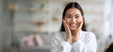 Barışçıl bir ortamda, Asyalı kadın cilt bakımı ve yaşlanmayı önleyici faydalara odaklanarak yüz masajı yaptırırken sevinç ifade ediyor. Tedavi rahatlama ve gençleştirme sunuyor..