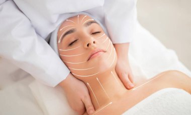 Bir kadın huzurlu bir kaplıcada gençleştirici yüz masajından hoşlanır. Cilt bakımı rutini yaşlanmayı önleme tekniklerini içerir. Yetenekli bir terapist olarak yüzü ve boynu üzerinde nazikçe çalışır..