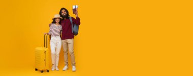 Ateşli seyahat, ucuz otel ya da biletler. Güzel genç doğu erkek ve kadın turistler birlikte seyahat ediyorlar, bavullarını ve sırt çantalarını taşıyorlar, pasaportlarını gösteriyorlar, fotokopi alanı, tam boy