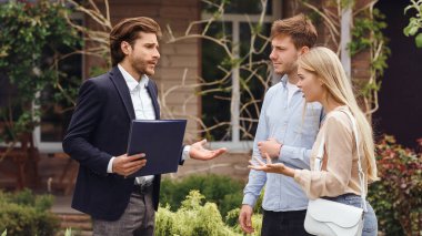 Mutsuz müşteriler ev alımı hakkında yöneticiyle tartışıyor.