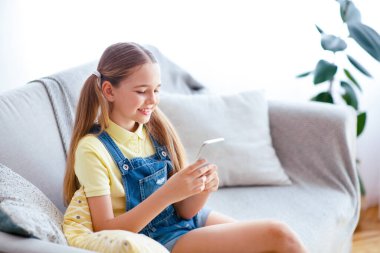 Harika bir uygulama. At kuyruklu, akıllı telefon kullanan, daktilo yazan ve mesaj gönderen sıradan, mutlu genç bir çocuk.