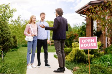 Kendine güveni tam bir emlakçı. Yeni evli genç bir çifte satılık ev gösteriyor.