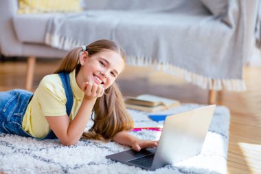 İnternete göz atıyorum. Oturma odasındaki halının üzerine uzanmış, kamera önünde poz veren, fotokopi çeken neşeli kız portresi.