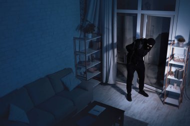 Haneye tecavüz kavramı. Gece eve gizlice giren biri, elinde levyeyle, kameranın üst görüntüsü, yüksek açılı.