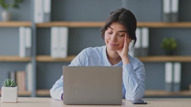 Genç bir kadın evinden aldığı online ders sırasında dizüstü bilgisayarına odaklanıyor. Eğitmen ya da öğretmen gibi görünüyor, uzaktan eğitim sağlamakla meşgul..