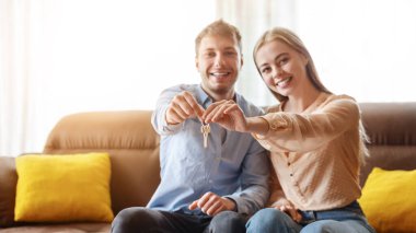 Yeni evlerinin anahtarını elinde tutan mutlu erkek arkadaşı olan güzel bir milenyum kızı.