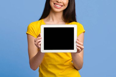 Siyah ekranlı dijital tabletin görüntüsü tanınmayan esmer kızın ellerinde, mor arkaplan, kopyalama alanı