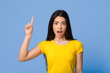 Harika bir fikir. Heyecanlı Asyalı Genç Kadın Parmak Kalkmış İlham Anı 'nı Gösteriyor, Milenyum Koreli Kadın Çözümü Buldu, Mor Stüdyo Arkaplanda Duruyor ve Kameraya Bakıyor, Uzayı Kopyala