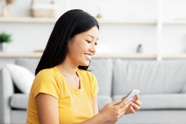 Milenyum Koreli bir kadın cep telefonuyla Jack Russell Terrier 'in fotoğrafını çekiyor. Şirin köpeğini sosyal medyada, oturma odasında, iç mekanda, fotokopi odasında arkadaşlarıyla paylaşıyor.