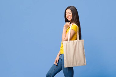 Çevre dostu yaşam tarzı. Neşeli Asyalı Kız Poz Veriyor Boş Tote Eko Torbası Mor Stüdyo Arkaplanı Üzerinde, Boşluğu Kopyala