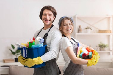 Bahar temizliğine hazırım. Elinde ev eşyaları olan gülen bir çift evde poz veriyor, boşluğu kopyalıyor.