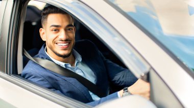 Neşeli Arap iş adamı güzel bir araba kullanıyor, genç bir orta doğulu yönetici ya da girişimci, işten işe koşuyor, yakından çekilmiş bir resim, kameraya bakıyor ve gülümsüyor, boşluğu kopyalıyor.