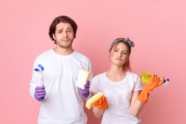 Temizlik İşleri Konsepti. Elleri Pembe Arkaplanda duran Evcil Aletleri Olan Hoşnut Olmayan Adam ve Kadın, Boşluğu Kopyala