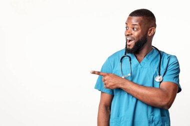 Duygusal Afrikalı Amerikalı doktor boş alana bakıyor ve işaret ediyor, panorama