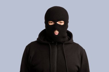 İsyanlar, Hırsızlık ve Yağmacılık Konsepti. Siyah maskeli kötü adamın portresi beyaz arka planda kameraya poz veriyor.