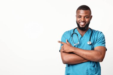 Klinik için harika bir teklif. Üniformalı yakışıklı dişlek afro doktor boş yeri işaret ediyor, panorama