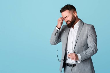 Stresli işadamı hata yüzünden ağlıyor ya da mavi arka plan yüzünden baş ağrısı çekiyor.