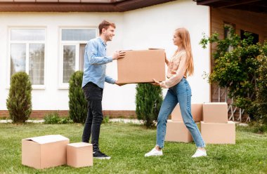 Taşındıkları gün yeni evlerinin önünde karton kutuları olan mutlu bir milenyum çifti