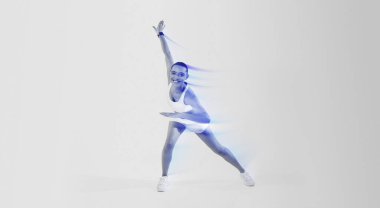 A joyful woman with a shaved head in a dynamic yoga pose, wearing a white sports outfit and sneakers, smiles widely on a gradient pink and yellow background, expressing energy and happiness