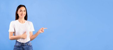 Şuna bak. Gülümseyen kız telif alanını işaret ediyor ve parmaklarını turkuaz stüdyo duvarında soyutlanmış bir şekilde gösteriyor.