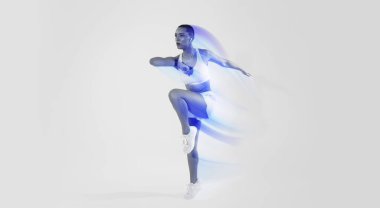 Bin yıllık Latin kadın spor giyim, kablosuz kulaklıklar çalışıyor, atlıyor, aktif egzersiz yapıyor, neon pembe stüdyo arka planında müzik dinliyor. Vücut bakımı, kardiyo sporu, tam boy