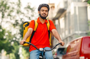 Teslimat adresini ara. Sarı sırt çantalı kurye sokakta bisiklet sürüyor, boş yer var.