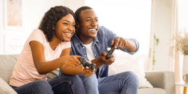 Duygusal Afrikalı Amerikalı çift evdeki oturma odasında video oyunu oynuyor, boşluğu kopyalıyorlar.