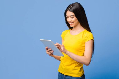 Gülümseyen Asyalı Kız, Dijital Tablet 'te Sosyal Ağları Mor Arkaplan Üzerinde Tarıyor, Modern Teknolojileri Seviyor, Kopyalama Alanı