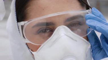 Açık havada giyinmiş genç bir Arap kadın, canlı bir sokak atmosferinin tadını çıkarırken koruyucu giysilerini ayarlıyor. Odaklanmış ve bir sonraki yarışmaya hazır görünüyor..