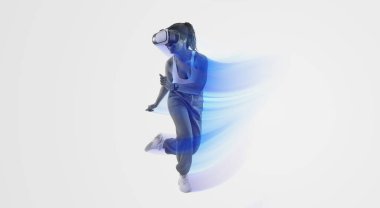 Metaevreni tecrübe ediyorum. Sanal gerçeklik gözlüklü aktif Afro-Amerikan bayan oyuncu pembe arka plan, boş alan. Stüdyoda 3 boyutlu deneyimin tadını çıkaran genç bir kadın.