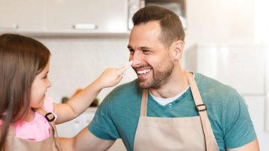 Eğlence Fırını Zamanı. Küçük kız babaya dokunuyor. Mutfakta birlikte Hamur yapıyor..