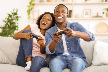 Duygusal Afrikalı aile babası karı koca evdeki oturma odasında video oyunu oynuyorlar, boşluğu kopyalıyorlar.
