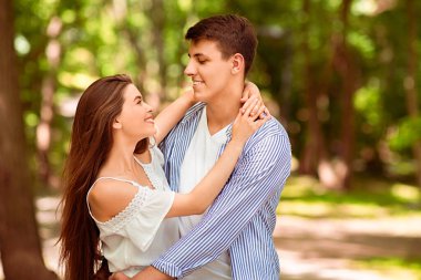 Genç evli çift sıcak bir yaz gününde birbirlerini kucaklıyorlar, boş bir alan.