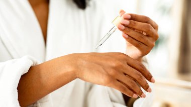 Vücut Bakımı. Tanınmayan Siyah Kadın Organik Nemlendirici Cildine Serum Veriyor, Banyo yaptıktan sonra kendini şımartıyor, Kesilmiş Görüntü, Kapanış