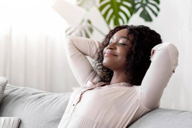 Hafta sonu evde. Rahat siyah kadın arkasını yaslıyor, gözleri kapalı koltuğa yaslanıyor, rahat bir oturma odasında ellerini başının arkasına koyup dinleniyor, izin gününün keyfini çıkarıyor, boşluğu kopyalıyor.