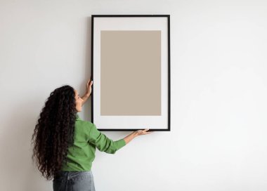 Beyaz Duvara Boş Poster Asan Mutlu Kadın. Kapalı Kapılar ardında duruyor. Modern sanat, iç mimari ve ev dekorasyonu resim konsepti. Reklam İçin Model