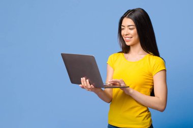 Çevrimiçi Eğitim. Gülümseyen Asyalı Kız Laptop Bilgisayarını Mor Arkaplanda Kullanıyor, Boşluğu Kopyala