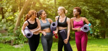 Parktaki sabah yoga antrenmanından önce spor giyim sektöründe çok ırklı kadınların tam boy portresi.