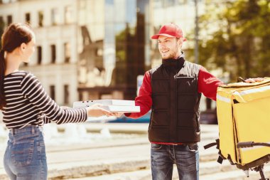 Kurye, Pizzacı Kız 'a Pizza Kutusu Veriyor. Dışarıdaki pizzacıdan yiyecek getiriyor. Seçici Odaklanma