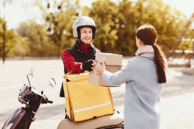 Yemek teslimatı. Dışarıdaki müşteriye restoran siparişiyle paket kutuları getiren kurye adam.