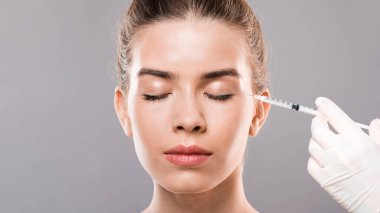 Genç bayanın göz kırışıklıkları, gri arka plan, boş alan aşıları.