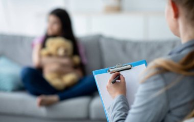 Gençlik bunalımı. Ofiste üzgün genç bir kızla çalışan psikolog, hastasıyla konuşuyor, notlar alıyor, seçici bir şekilde odaklanıyor. Mutsuz ergen psikoterapistle görüşüyor, fotokopi çekiyor.