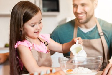 Neşeli bir baba ve kızı evde birlikte hamur işi pişiriyorlar. Aile Hafta Sonu Konsepti. Seçici Odaklanma