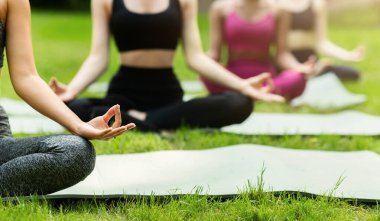 Genç kadınların parkta yoga ya da meditasyon yaptığı yakın çekim görüntüsü, boş alan