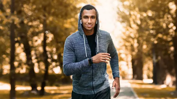 Gülümseyen siyah atlet yazın Green Park 'ta maratona hazırlanıyor, panorama